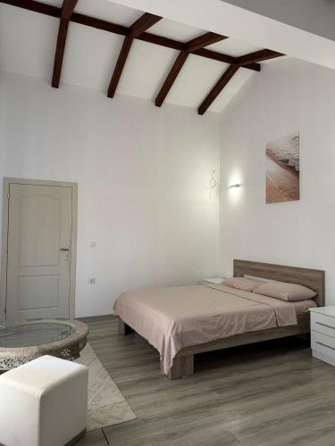 a white bedroom with a bed and a tub at Kelesina Apartment in Ulcinj
