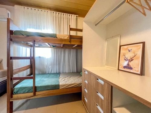 a bunk room with two bunk beds and a desk at Jungla House Hostel in Alto Paraíso de Goiás