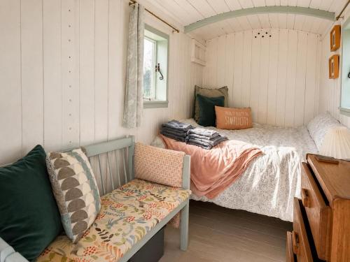 a bedroom with two beds and a couch at Mabel the Steam Roller Caravan at Rosuick Organic Farm in Saint Martins Green