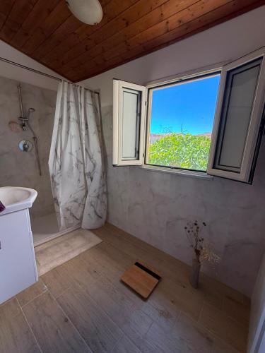 a bathroom with a shower and a sink and a window at Casa Bella Tania in Briatico