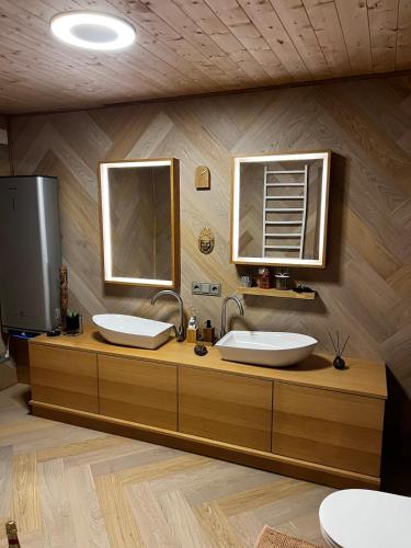 ein Badezimmer mit zwei Waschbecken und zwei Spiegeln in der Unterkunft Vila Strėva in Kozelkiskes