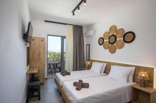 a hotel room with two beds and a balcony at GK Home Studios part of GK FITNESS CLUB in Faliraki