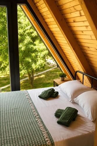 a bed with two green towels on it in front of a window at Trebižat Oasis in Čapljina