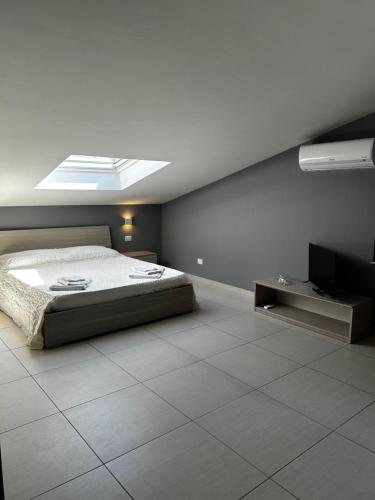 a bedroom with a bed and a television in it at L'attico di Greta,Etna house in Mascalucia