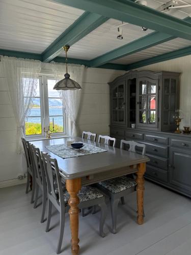 a dining room with a wooden table and chairs at Heritage House in Lofoten with Modern Comfort & Scenic Views in Jerstad