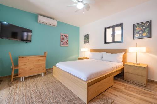 a bedroom with a large bed and a tv at Tropical Casa Laguna in Cabarete