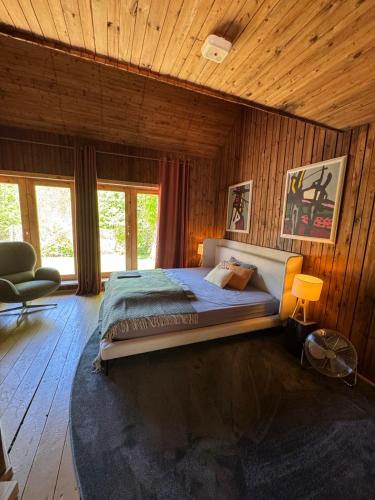 ein Schlafzimmer mit einem großen Bett in einem Holzzimmer in der Unterkunft Vila Strėva in Kozelkiskes