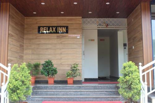 a lobby of a building with stairs and plants at Hotel Relax inn in Chikmagalūr