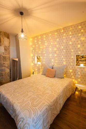 a bedroom with a bed with lights on the wall at Ancien Cloître rénové - Hyper centre - T2 de 50m2 in Mont-de-Marsan
