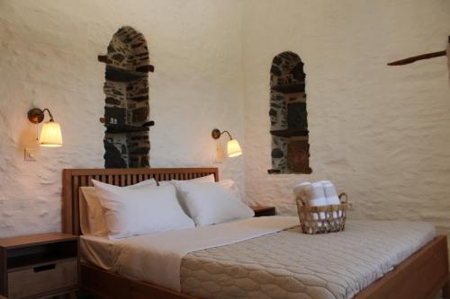 a bedroom with a bed with two arched windows at NeSi Cycladic Living in Ano Syros