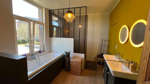 a bathroom with a tub and two sinks and a large window at Le Clos Boréal - Gîte Spa Privatif in Lens