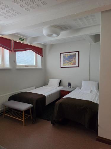 a room with two beds and a chair at Apartments Puistokatu in Savonlinna