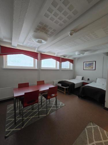 a room with two beds and a table and chairs at Apartments Puistokatu in Savonlinna