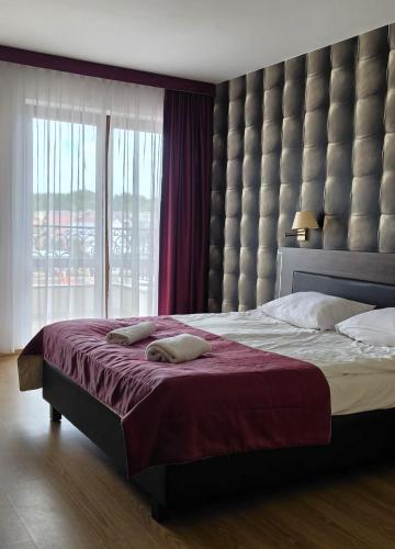 a bedroom with a large bed with a large window at Vacation Club Łeba in Łeba