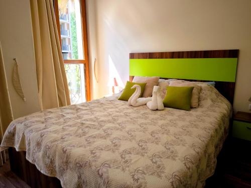 a bedroom with a bed with two stuffed animals on it at Cascadas, Studio apartment with a pool view in Sunny Beach