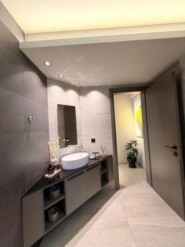 a bathroom with a sink and a mirror at Animus Premium apt in Nafplio