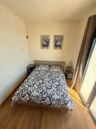a bedroom with a bed and two paintings on the wall at SUPERBE maison, rénovée port de Carro -terrasse,calme & lumière in Martigues