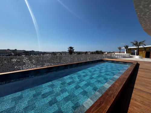 a swimming pool with blue water and a wooden deck at Le VIBES RESORT By AGN "réservé aux couples" in Cap d'Agde