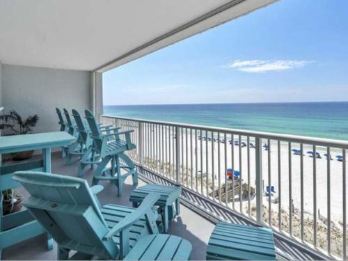 a balcony with chairs and a table and the ocean at Islander E 7011 Stunning oceanfront condo with pool & gym access in Fort Walton Beach