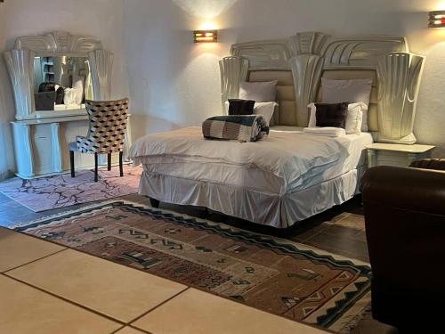 a bedroom with a large bed and a mirror at One love suites in Mokopane