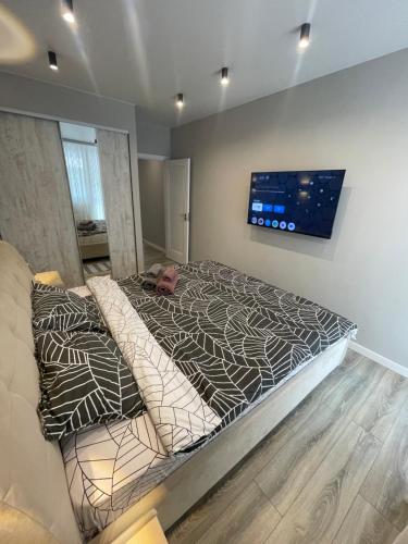 a bedroom with a bed and a tv on the wall at Buiucani Residence in Chişinău