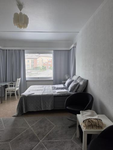 a bedroom with a bed and a chair and a window at Central Accommodation at Olavinkatu in Savonlinna