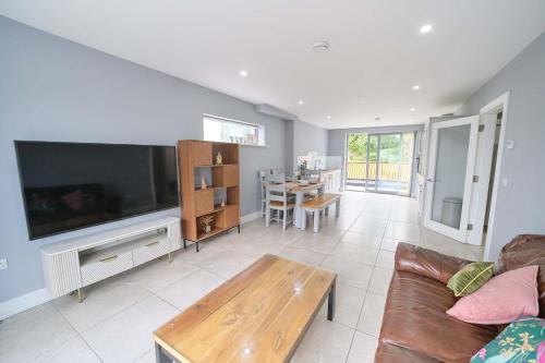 a living room with a large television and a table at 3 Bedroom Duplex Apartment By Travel Lets Short Term Rental Agency Donegal Town in Donegal