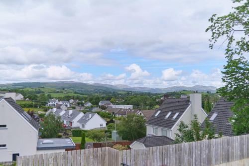 a town with houses and mountains in the background at 3 Bedroom Duplex Apartment By Travel Lets Short Term Rental Agency Donegal Town in Donegal