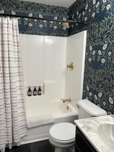 a bathroom with a toilet and a tub and a sink at Sea Fog Cottage in Camden