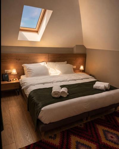 a bedroom with a large bed with two towels on it at Hotel Protino in Fushë-Prezë
