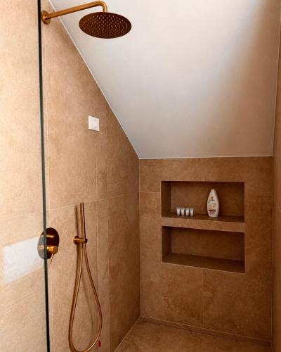 a bathroom with a shower with a shower head at Hotel Protino in Fushë-Prezë