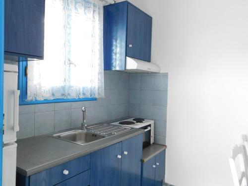 a kitchen with blue cabinets and a sink at Studio Elisabeth in Agios Ioannis