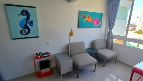 a waiting room with two chairs and a seahorse painting at Ocean View Studio in Playa del Ingles in San Bartolomé