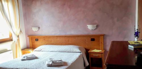 a bedroom with a bed with two shoes on it at Le Bottesele in San Zeno di Montagna
