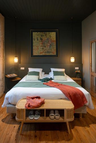 a bedroom with a large bed with shoes on it at La Sauternaise, luxury Boutique B&B in Sauternes