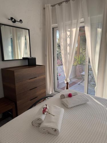 a bedroom with a bed with towels and a mirror at Villa eco Electra in Nikiti