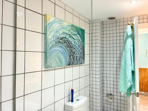 a bathroom with a painting of a wave on the wall at Apartamento Los Lagos Renovated New Kitchen & More in El Cotillo