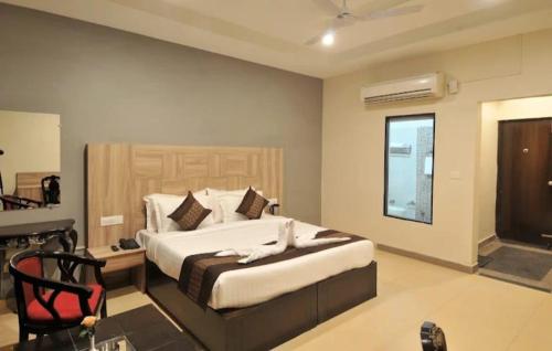 a bedroom with a bed and a chair in it at Eva Hotel in Zirakpur