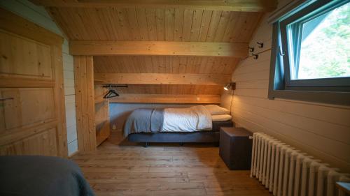 a small bedroom with a bed in a room with a window at Vakantiewoning Vrijburg in Schagerbrug