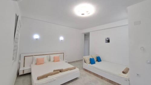 a white room with two beds and a couch at Apartments BIA in Gevgelija