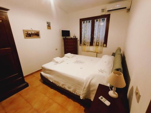 a bedroom with a white bed and a window at Villa Sonia in Maddalenedda