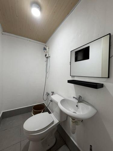 a bathroom with a toilet and a sink and a mirror at Maple Tree by The Guild Oasis Transient House in Rosario