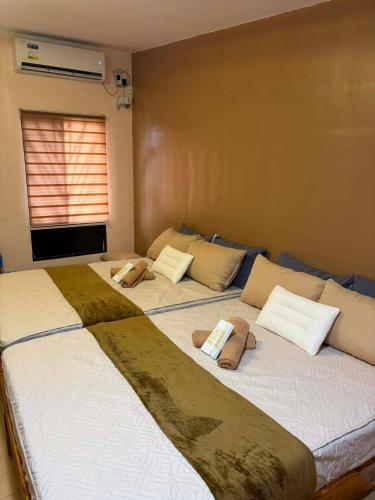 two beds sitting next to each other in a bedroom at Maple Tree by The Guild Oasis Transient House in Rosario