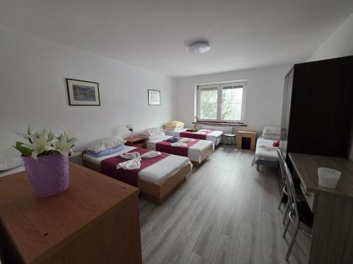 a room with four beds and a living room at Ночлеги - Pokoi in Tarnowo Podgórne