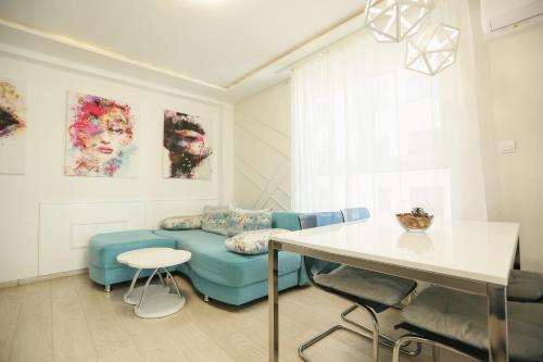 a living room with a blue couch and a table at Apartmani SLEEP&JOY in Zlatibor