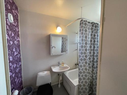 a small bathroom with a sink and a toilet at Fjord Hostel Rooms in Lysekil