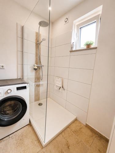 a bathroom with a washing machine and a shower at Quiet & Friendly Bremen in Bremen