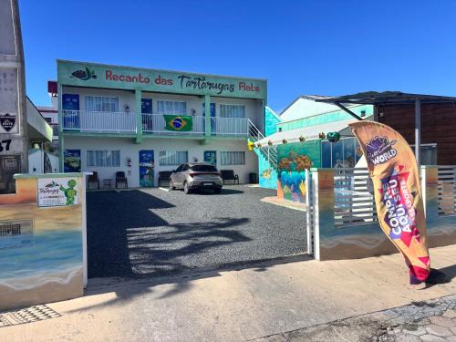 a gate with a surfboard in front of a building at Recanto das Tartarugas Flats in Penha