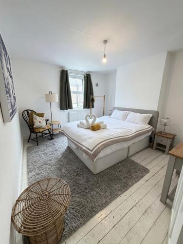 a bedroom with a large white bed and a chair at Summerfields cottage stylish Home in Hollington
