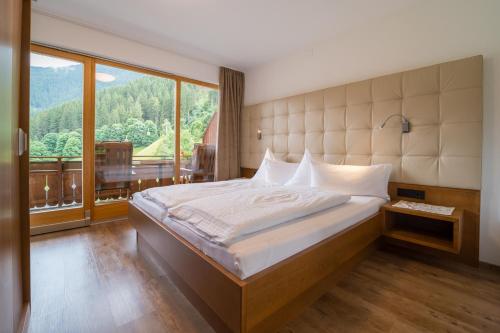 a bedroom with a large bed with a large window at Haus Schönlechner in Gaschurn
